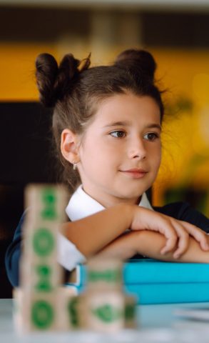 School girl in medical mask using laptop computer studying through online e-learning system.